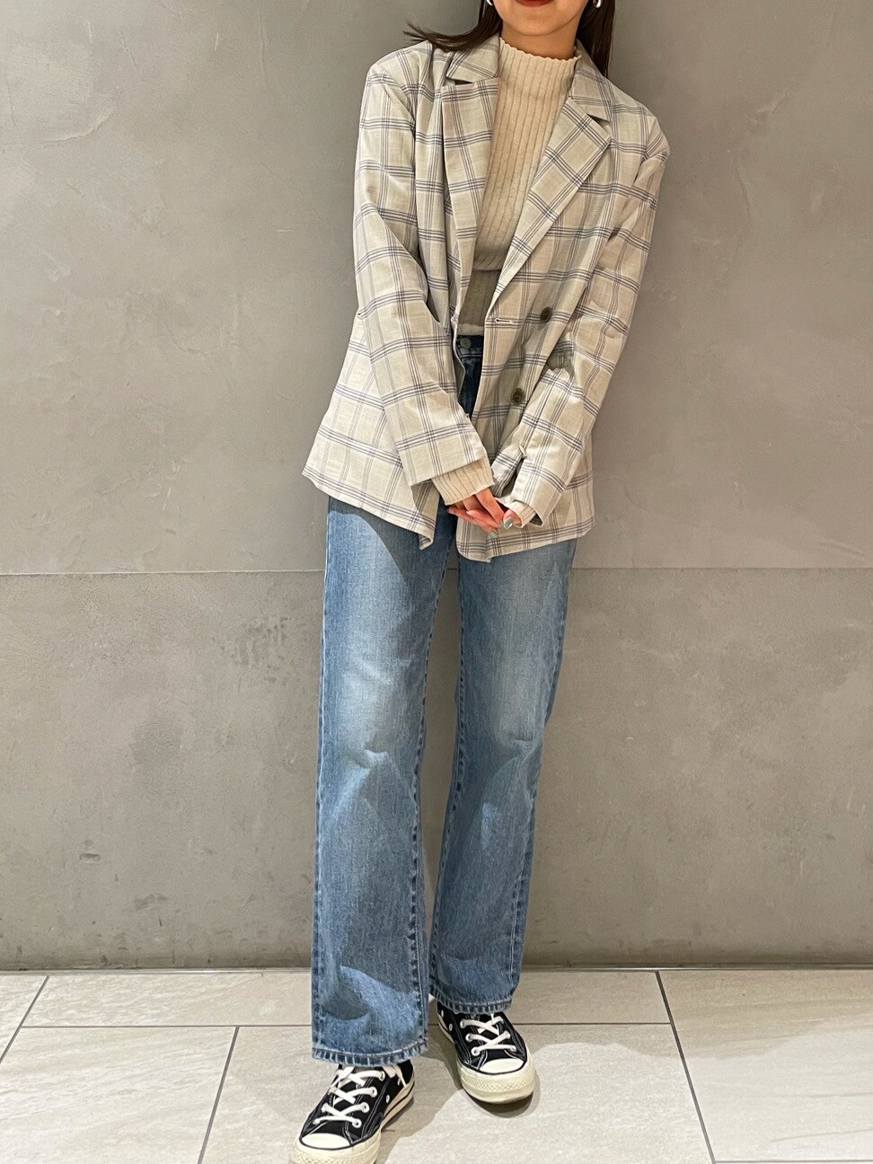 ブルー系のテーラードジャケット、ブルー系のデニムパンツ、ホワイト系のニット/セーターを着用したレディースの冬コーディネートの3枚目の写真