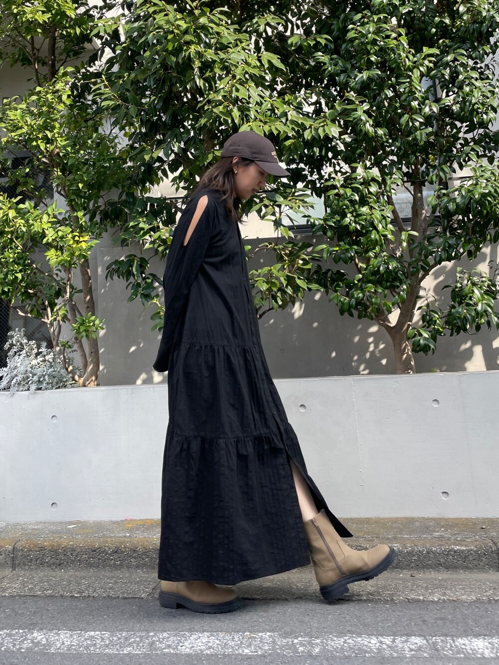 ブラック系のワンピース、ベージュ系のブーツ、グレー系のキャップを着用したレディースの冬コーディネートの6枚目の写真