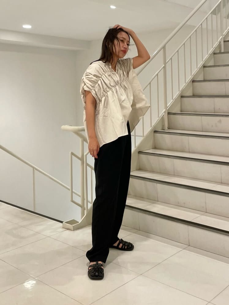 ブラック系のスラックス、ホワイト系のシャツ/ブラウスを着用したレディースの夏コーディネートの3枚目の写真