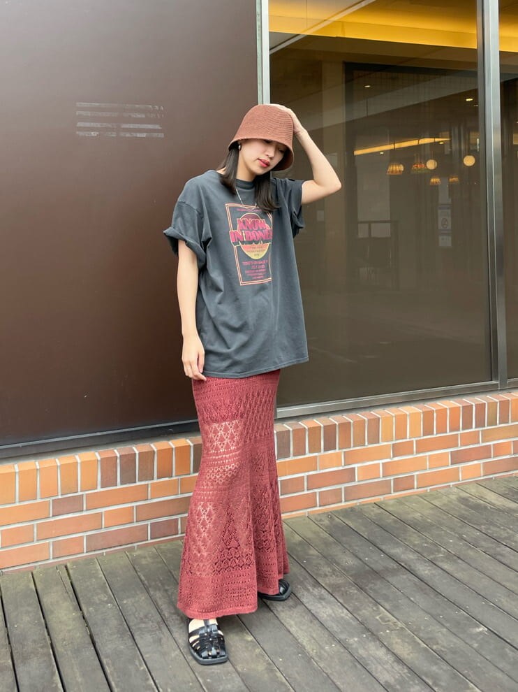 グレー系のTシャツ/カットソー、オレンジ系のスカート、ブラウン系のハットを着用したレディースの春コーディネートの4枚目の写真