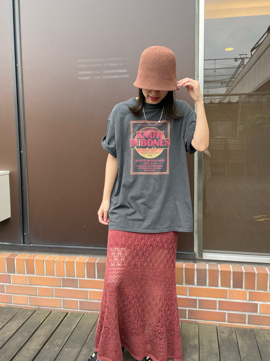グレー系のTシャツ/カットソー、オレンジ系のスカート、ブラウン系のハットを着用したレディースの春コーディネートの9枚目の写真