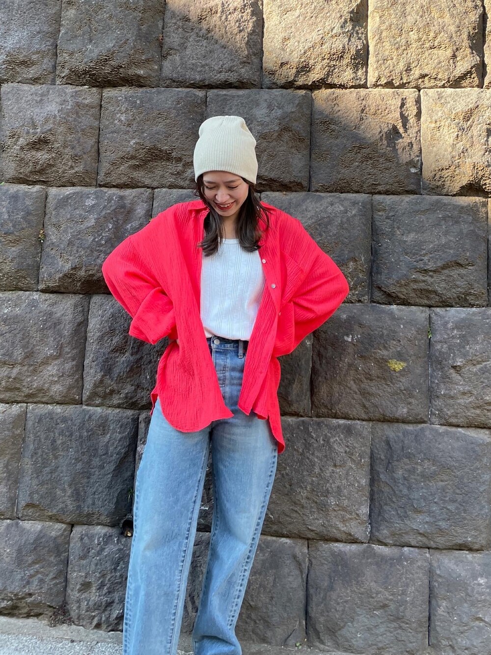 ブルー系のデニムパンツ、オレンジ系のシャツ/ブラウス、ホワイト系のタンクトップを着用したレディースの冬コーディネートの2枚目の写真