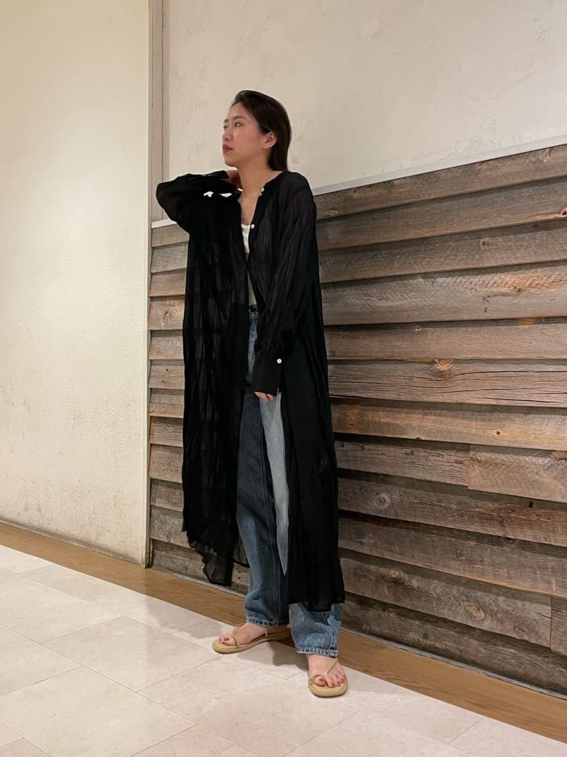 ブルー系のデニムパンツ、ブラック系のワンピース、グリーン系のサンダルを着用したレディースの夏コーディネートの7枚目の写真