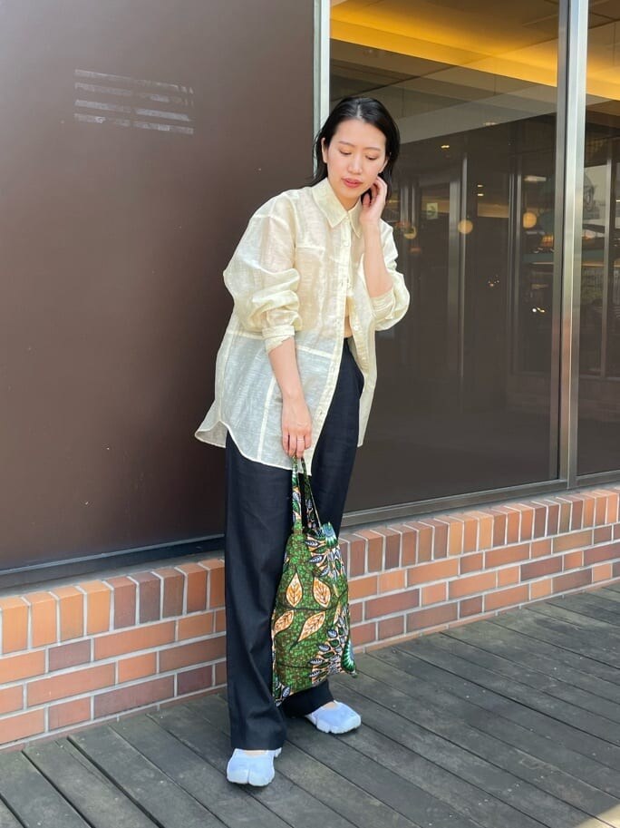 オレンジ系のタンクトップ、ベージュ系のシャツ/ブラウス、ブラック系のその他パンツを着用したレディースの春コーディネートの3枚目の写真