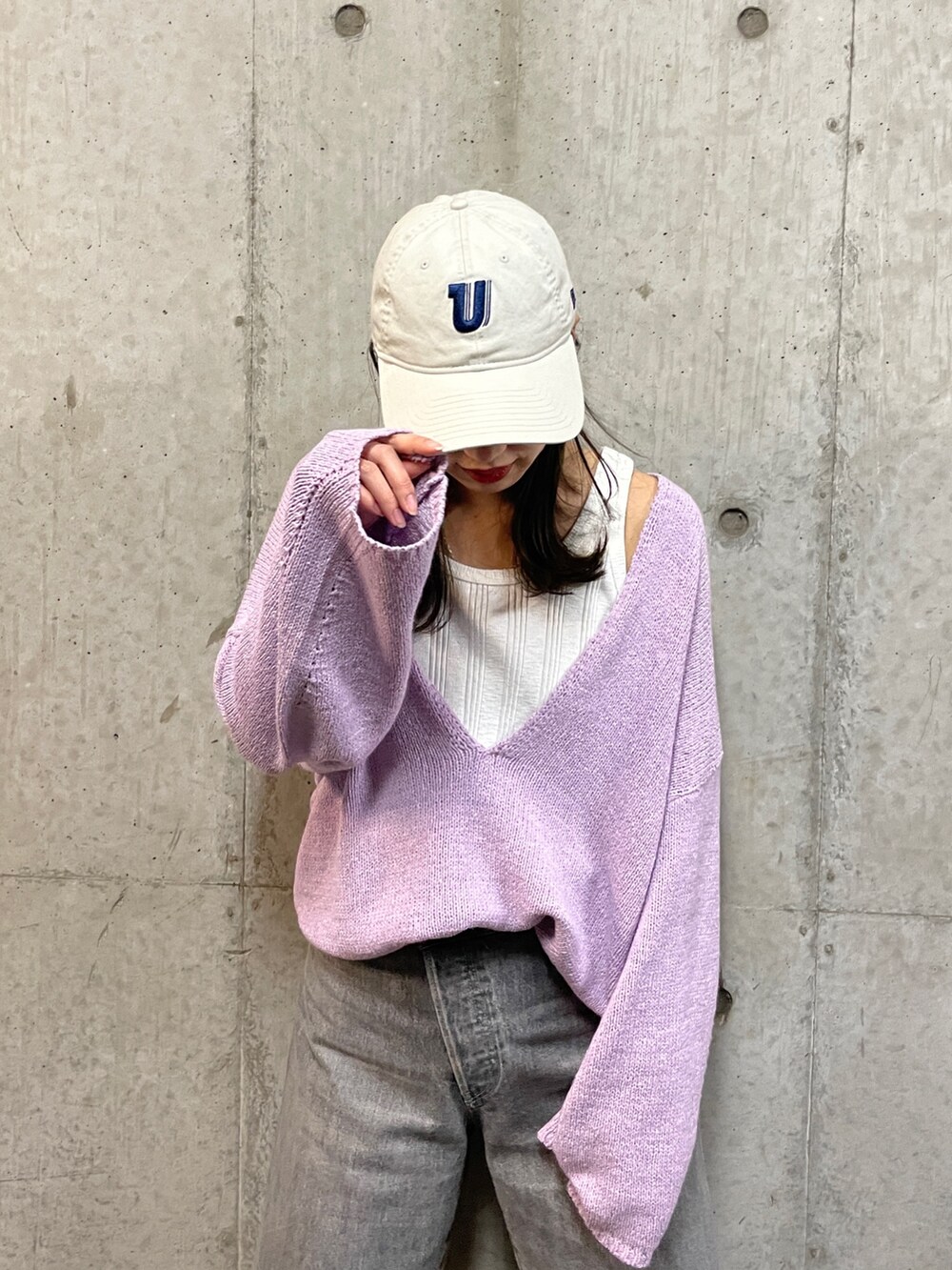 パープル系のニット/セーター、ブラック系のデニムパンツ、ホワイト系のタンクトップを着用したレディースの冬コーディネートの7枚目の写真