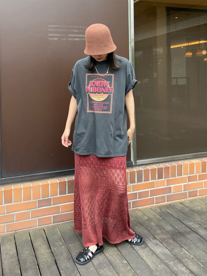 グレー系のTシャツ/カットソー、オレンジ系のスカート、ブラウン系のハットを着用したレディースの春コーディネートの3枚目の写真
