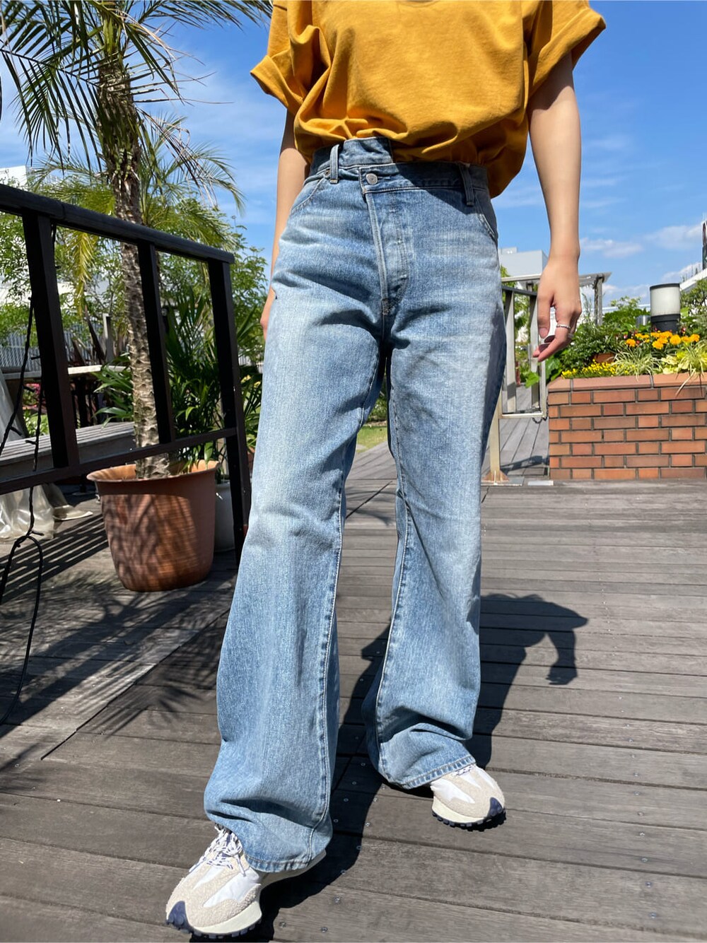 イエロー系のTシャツ/カットソー、ブルー系のデニムパンツを着用したレディースの春コーディネートの10枚目の写真