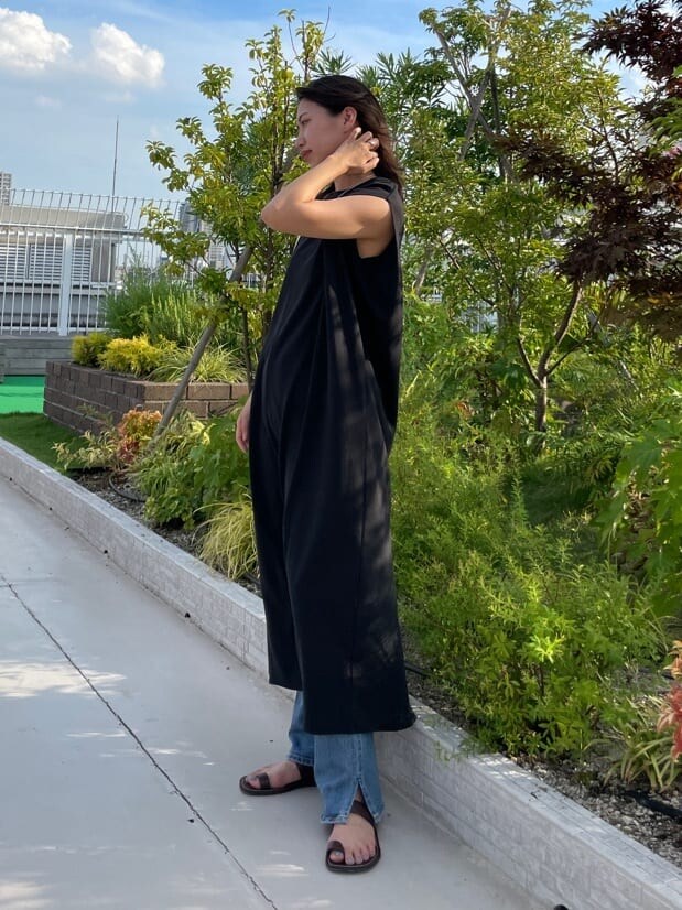 ブラック系のワンピース、ブルー系のデニムパンツを着用したレディースの夏コーディネートの3枚目の写真