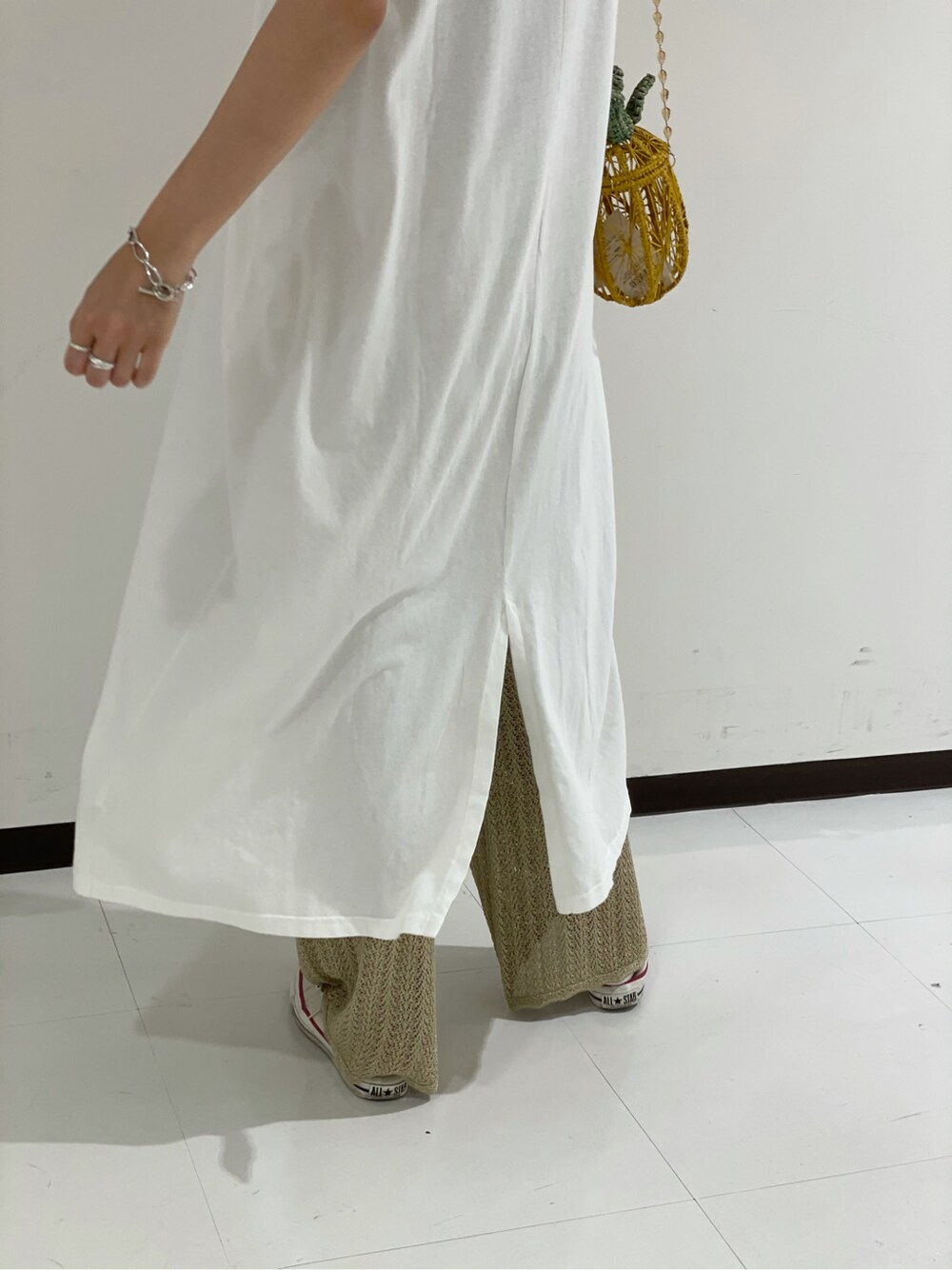 ホワイト系のワンピース、ゴールド系のその他パンツ、イエロー系のショルダーバッグを着用したレディースの夏コーディネートの3枚目の写真