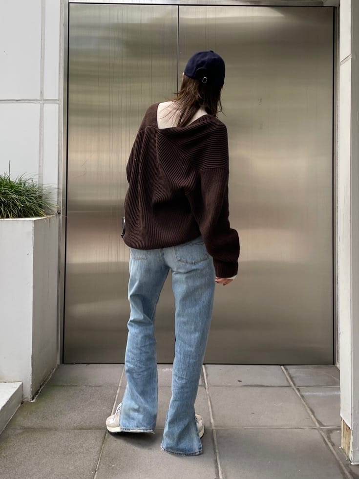 ブラック系のクラッチバッグ、ブルー系のデニムパンツ、ブルー系のデニムパンツを着用したレディースの秋コーディネートの3枚目の写真