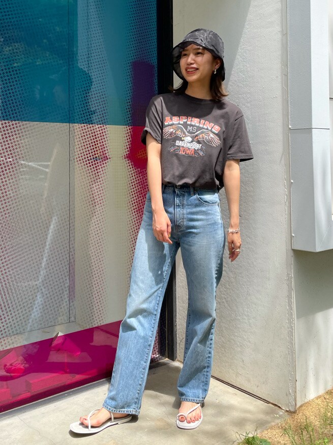 グレー系のTシャツ/カットソー、ブルー系のデニムパンツ、ホワイト系のサンダルを着用したレディースの春コーディネートの2枚目の写真