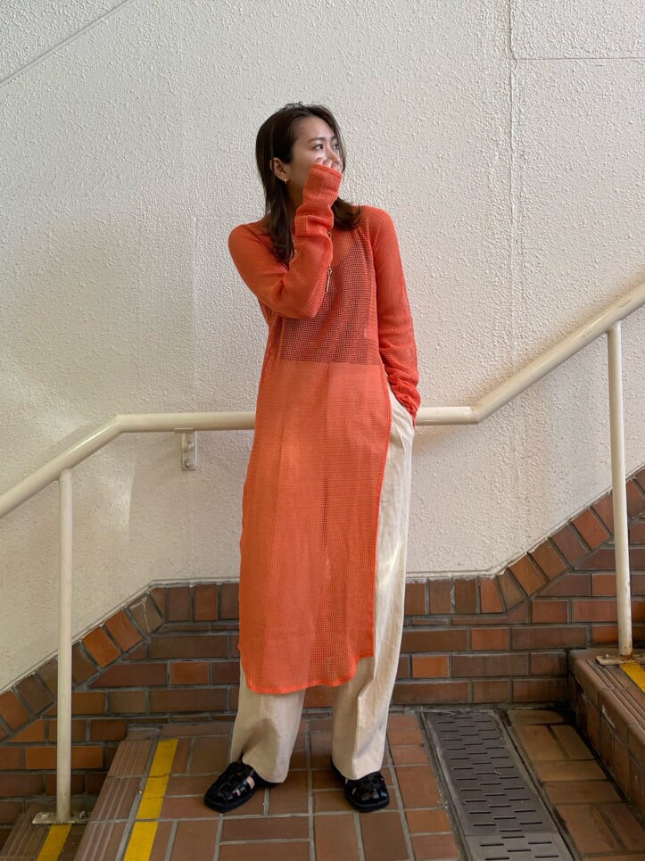 オレンジ系のワンピース、ブラック系のサンダル、ホワイト系のその他パンツを着用したレディースの春コーディネートの3枚目の写真