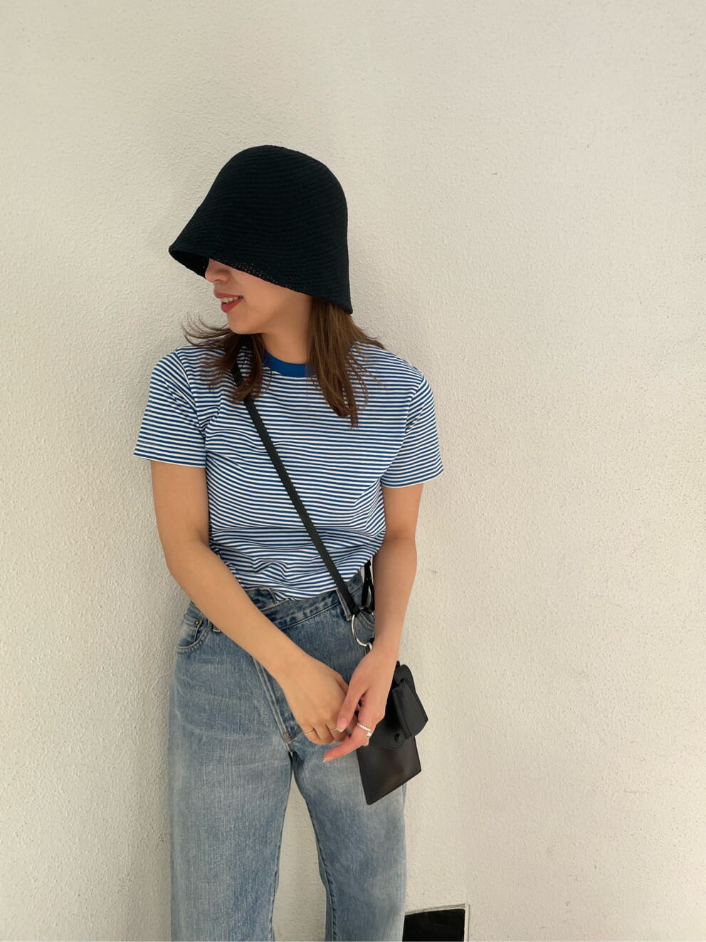 ブラック系のショルダーバッグ、ブルー系のTシャツ/カットソー、ブラック系のサンダルを着用したレディースの春コーディネートの5枚目の写真
