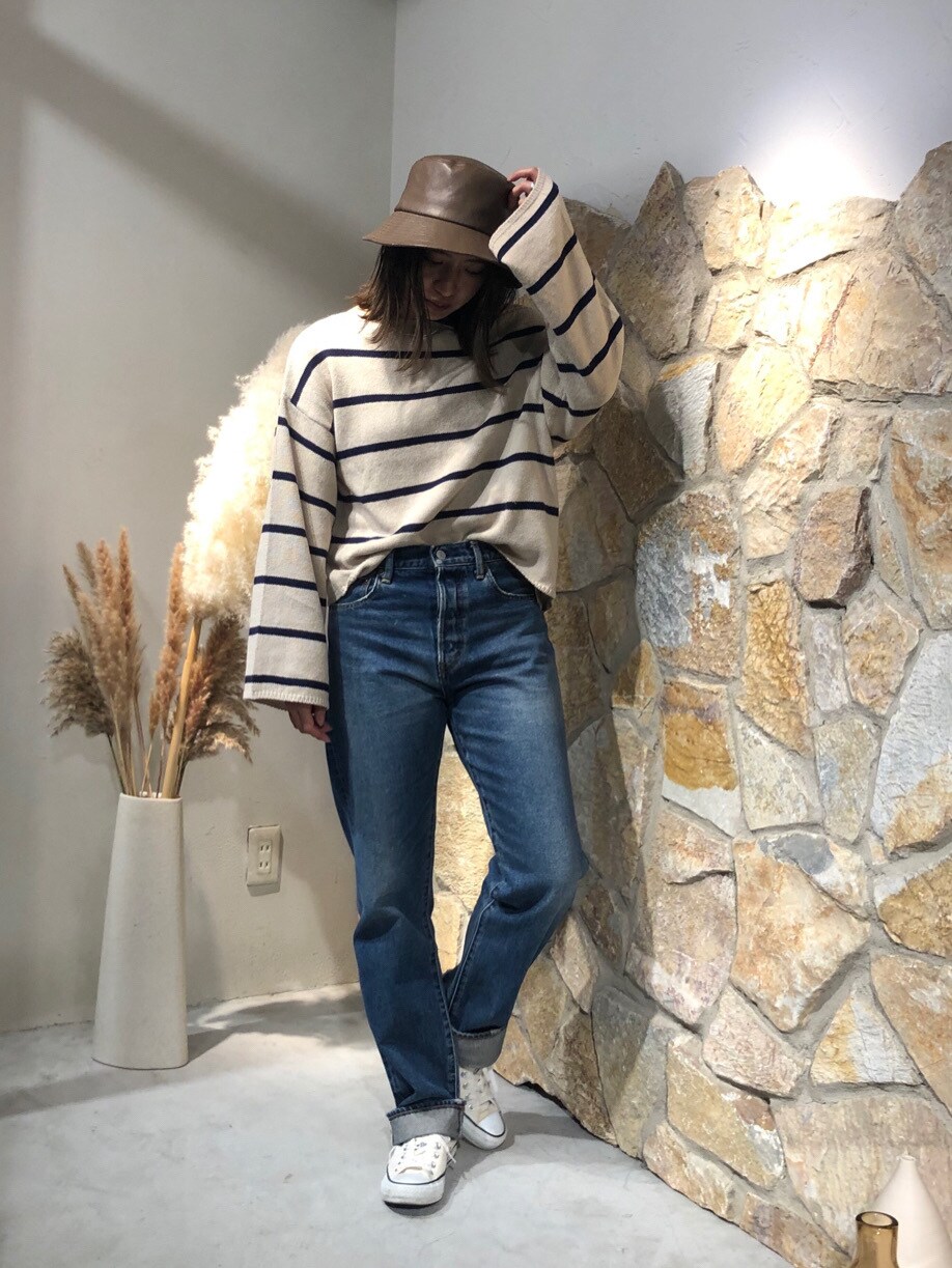 ブルー系のニット/セーター、ブルー系のデニムパンツ、ブラウン系のハットを着用したレディースの秋コーディネートの2枚目の写真