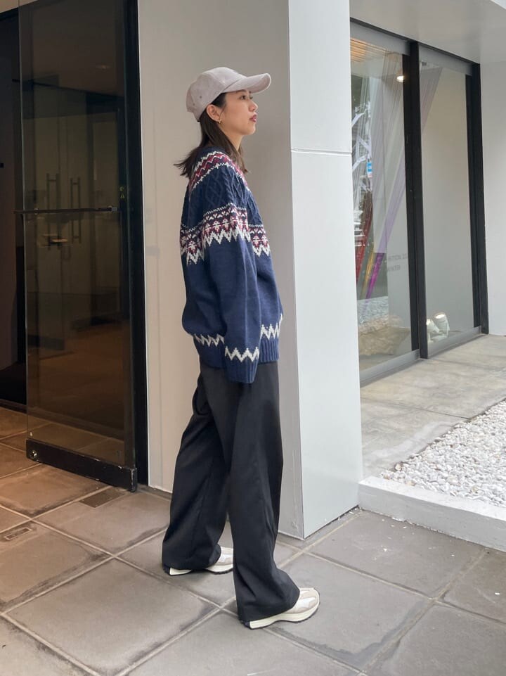 グレー系のスラックス、ブルー系のニット/セーター、グレー系のキャップを着用したレディースの秋コーディネートの3枚目の写真