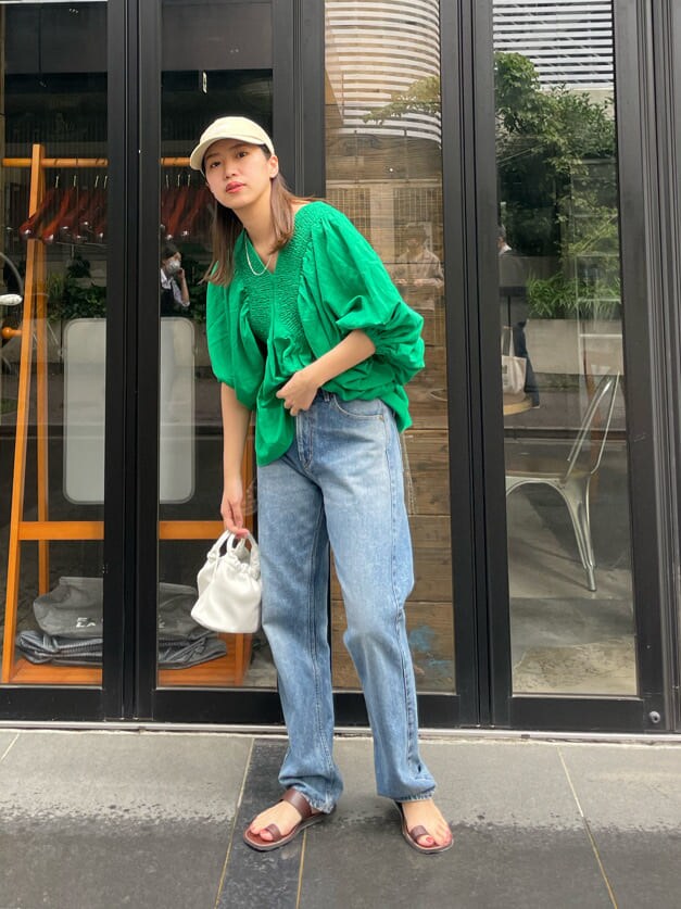 グリーン系のシャツ/ブラウス、ブラウン系のサンダル、ブルー系のデニムパンツを着用したレディースの夏コーディネートの2枚目の写真