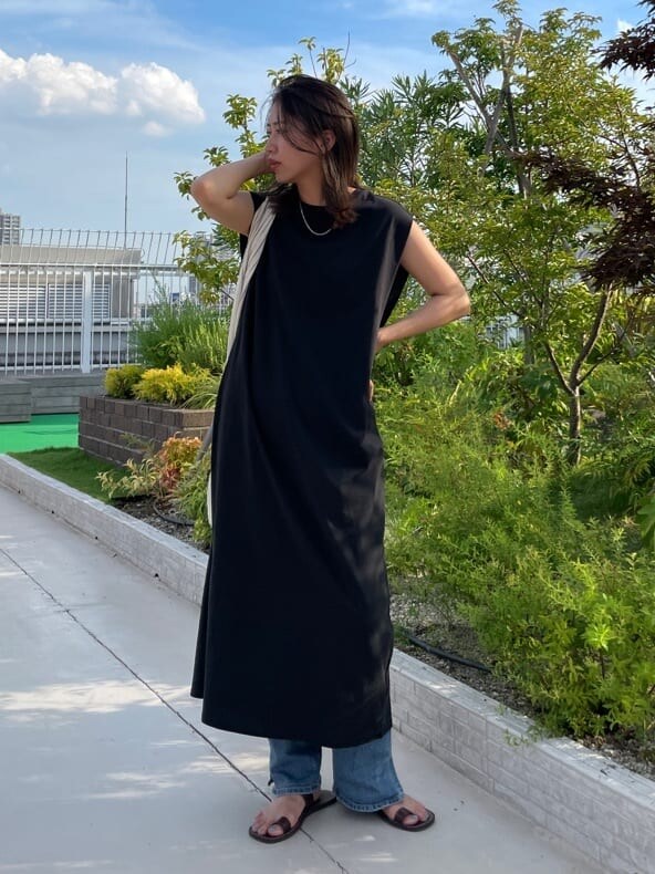 ブラック系のワンピース、ブルー系のデニムパンツを着用したレディースの夏コーディネートの6枚目の写真