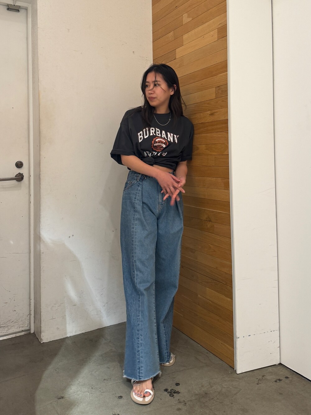 ブルー系のデニムパンツ、グレー系のTシャツ/カットソー、ブラック系のサンダルを着用したレディースの春コーディネートの2枚目の写真