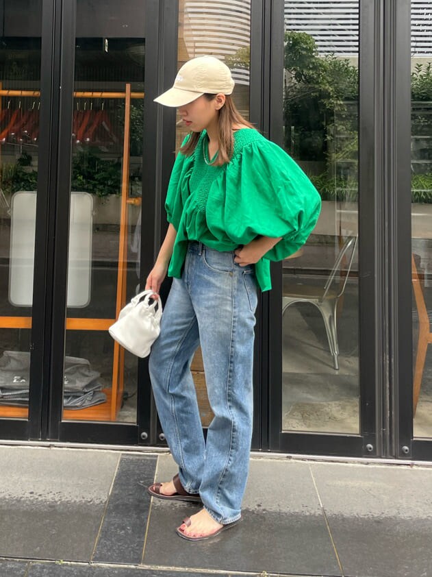 グリーン系のシャツ/ブラウス、ブラウン系のサンダル、ブルー系のデニムパンツを着用したレディースの夏コーディネートの5枚目の写真