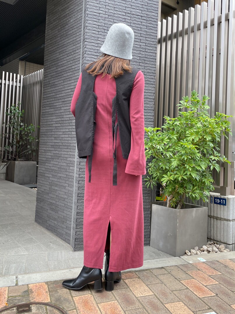 ブラック系のブルゾン、レッド系のワンピース、ブラック系のブーツを着用したレディースの夏コーディネートの5枚目の写真