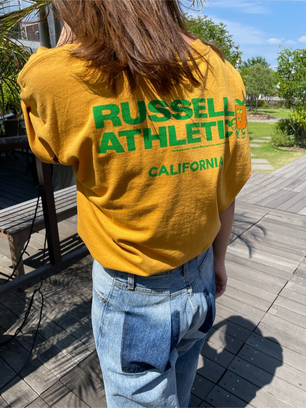 イエロー系のTシャツ/カットソー、ブルー系のデニムパンツを着用したレディースの春コーディネートの7枚目の写真