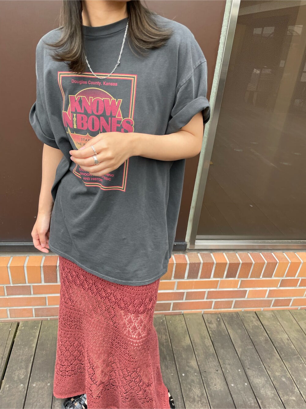 グレー系のTシャツ/カットソー、オレンジ系のスカート、ブラウン系のハットを着用したレディースの春コーディネートの5枚目の写真