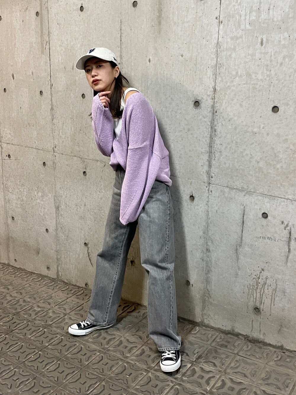 パープル系のニット/セーター、ブラック系のデニムパンツ、ホワイト系のタンクトップを着用したレディースの冬コーディネートの6枚目の写真