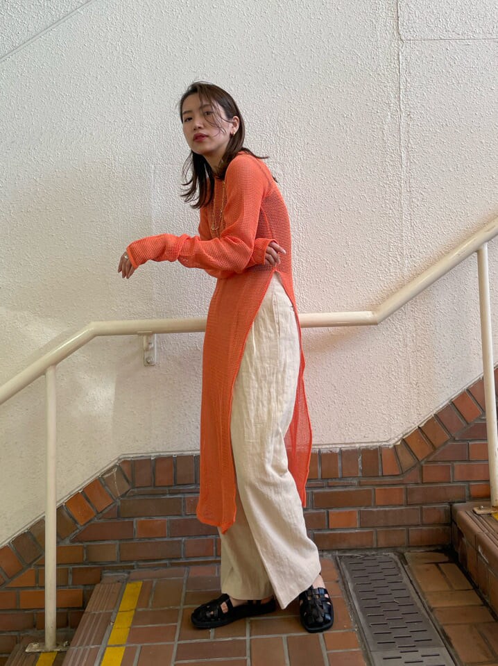 オレンジ系のワンピース、ブラック系のサンダル、ホワイト系のその他パンツを着用したレディースの春コーディネートの4枚目の写真