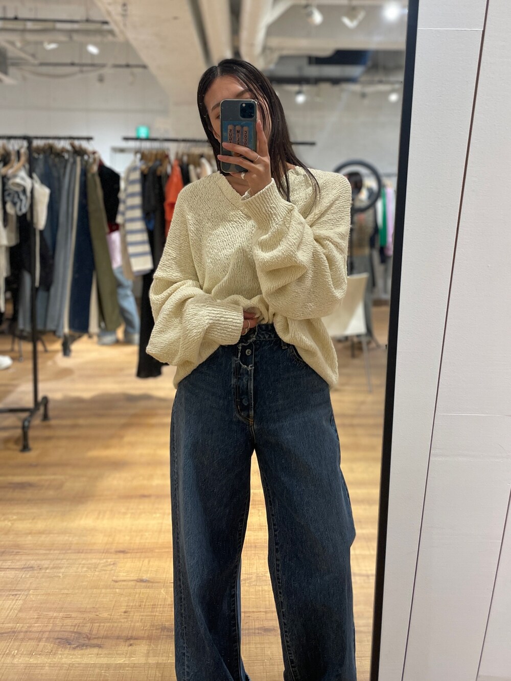 ブルー系のデニムパンツ、ホワイト系のニット/セーター、ブラウン系のローファーを着用したレディースの冬コーディネートの3枚目の写真