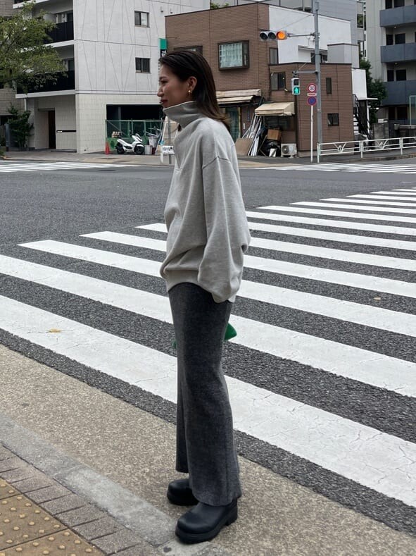 グリーン系のクラッチバッグ、グレー系のスウェット、グレー系のスカートを着用したレディースの秋コーディネートの2枚目の写真