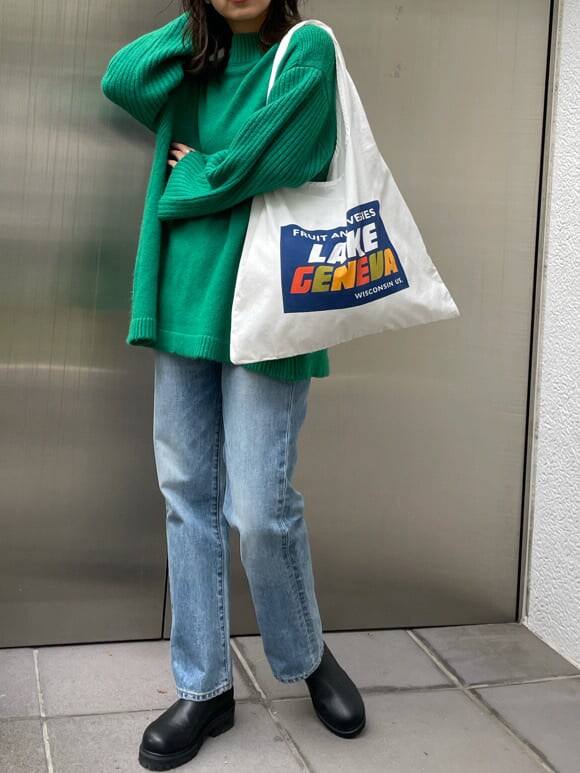 ブルー系のデニムパンツ、ホワイト系のエコバッグ/サブバッグ、グリーン系のニット/セーターを着用したレディースの秋コーディネートの6枚目の写真