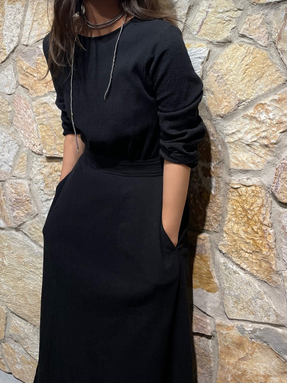 ブラック系のワンピース、シルバー系のサンダル、シルバー系のネックレスを着用したレディースの春コーディネートの2枚目の写真