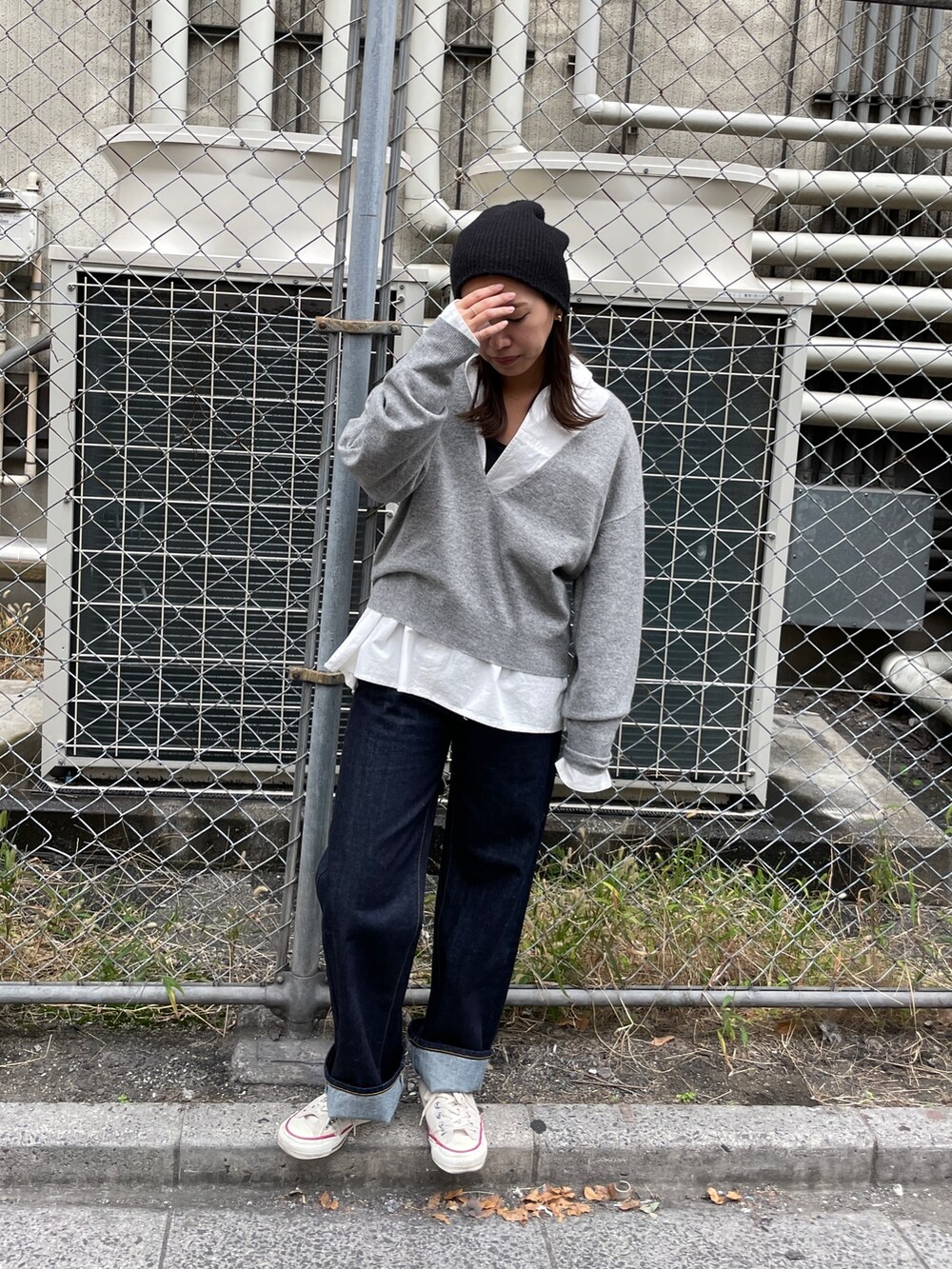 グレー系のニット/セーター、ブルー系のデニムパンツ、ホワイト系のシャツ/ブラウスを着用したレディースの秋コーディネートの2枚目の写真