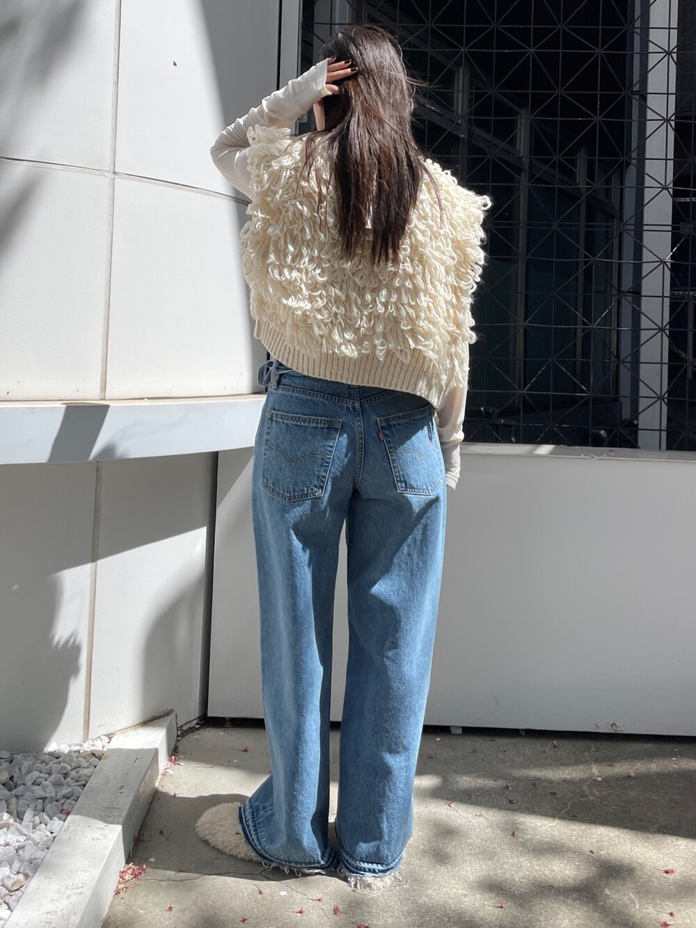 ブルー系のデニムパンツ、ホワイト系のベスト、ホワイト系のTシャツ/カットソーを着用したレディースの夏コーディネートの4枚目の写真