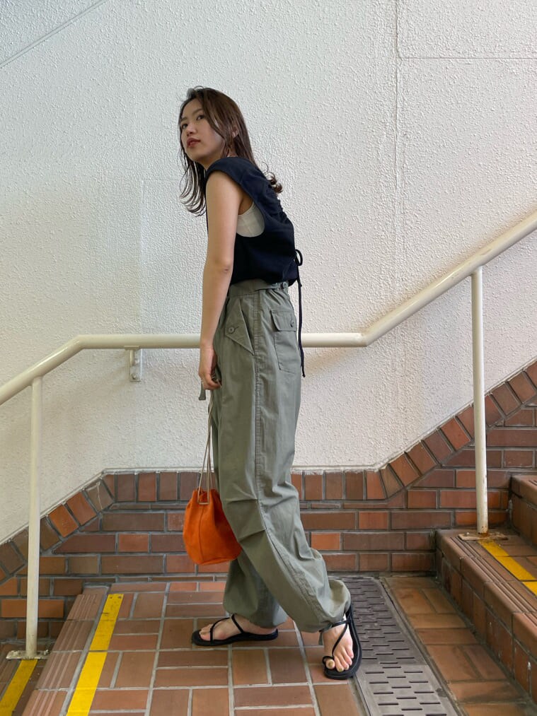 ブラック系のサンダル、オレンジ系のハンドバッグ、ベージュ系のその他パンツを着用したレディースの春コーディネートの4枚目の写真