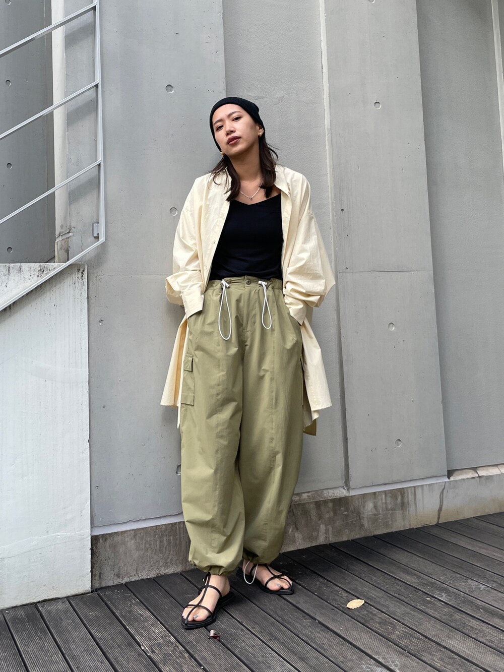 グリーン系のカーゴパンツ、イエロー系のシャツ/ブラウス、ブラック系のサンダルを着用したレディースの秋コーディネートの2枚目の写真