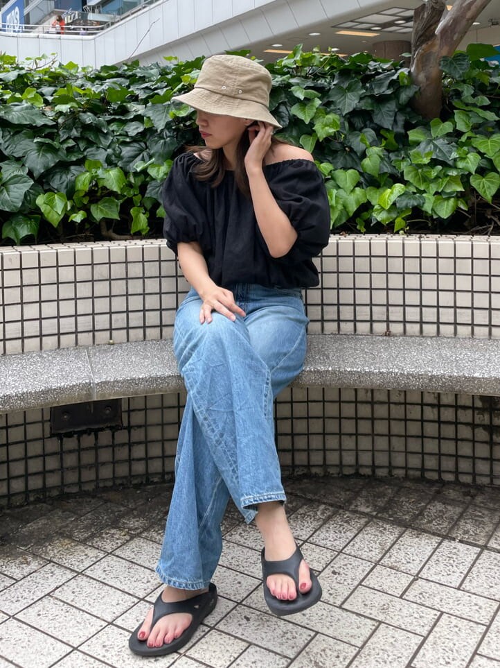 ブラック系のシャツ/ブラウス、ブルー系のデニムパンツ、ホワイト系のハットを着用したレディースの夏コーディネートの3枚目の写真