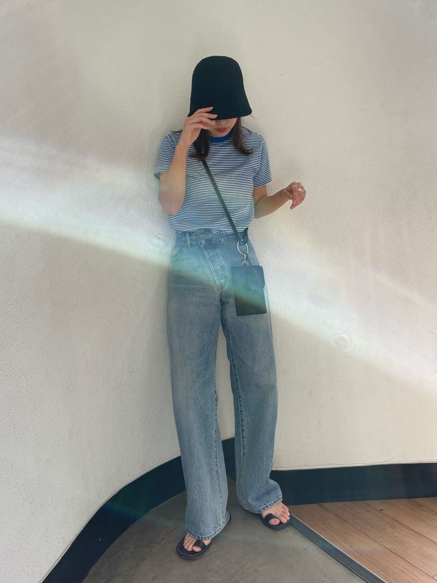 ブラック系のショルダーバッグ、ブルー系のTシャツ/カットソー、ブラック系のサンダルを着用したレディースの春コーディネートの2枚目の写真