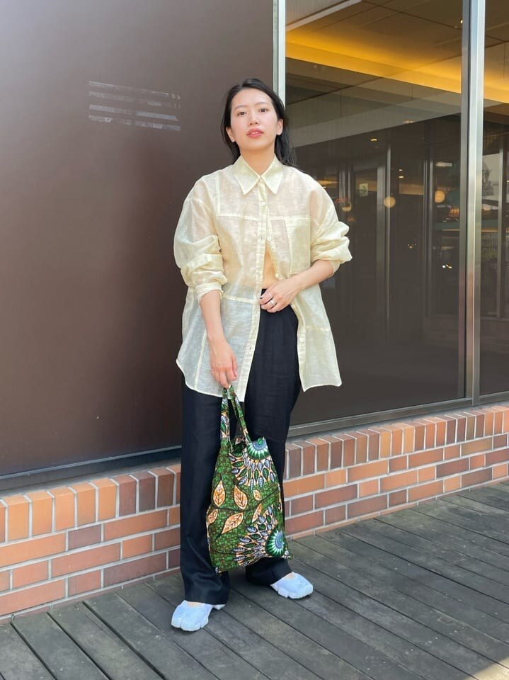 オレンジ系のタンクトップ、ベージュ系のシャツ/ブラウス、ブラック系のその他パンツを着用したレディースの春コーディネートの2枚目の写真