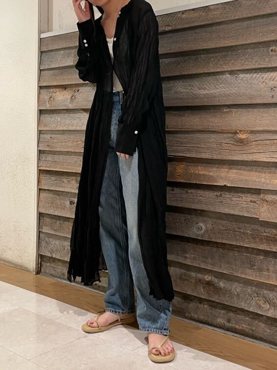 ブルー系のデニムパンツ、ブラック系のワンピース、グリーン系のサンダルを着用したレディースの夏コーディネートの6枚目の写真