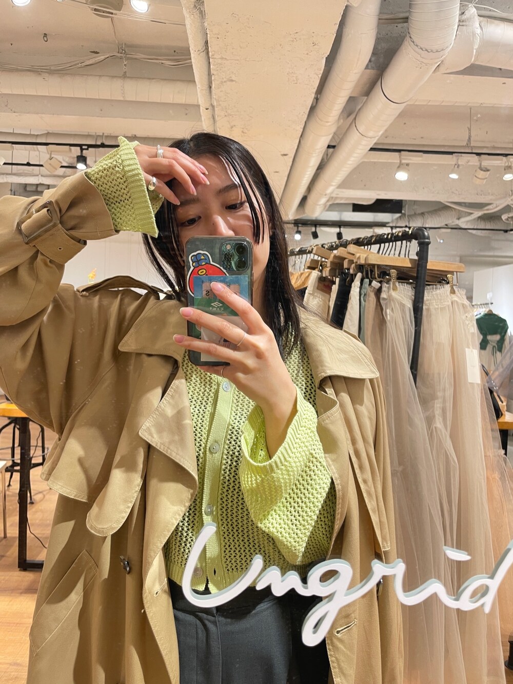 ベージュ系のトレンチコート、グリーン系のカーディガン/ボレロを着用したレディースの冬コーディネートの5枚目の写真