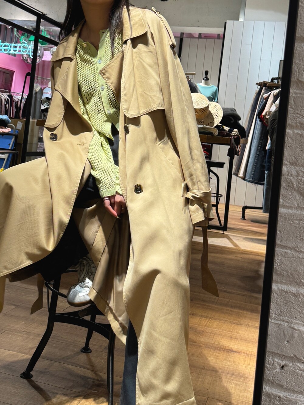 ベージュ系のトレンチコート、グリーン系のカーディガン/ボレロを着用したレディースの冬コーディネートの4枚目の写真