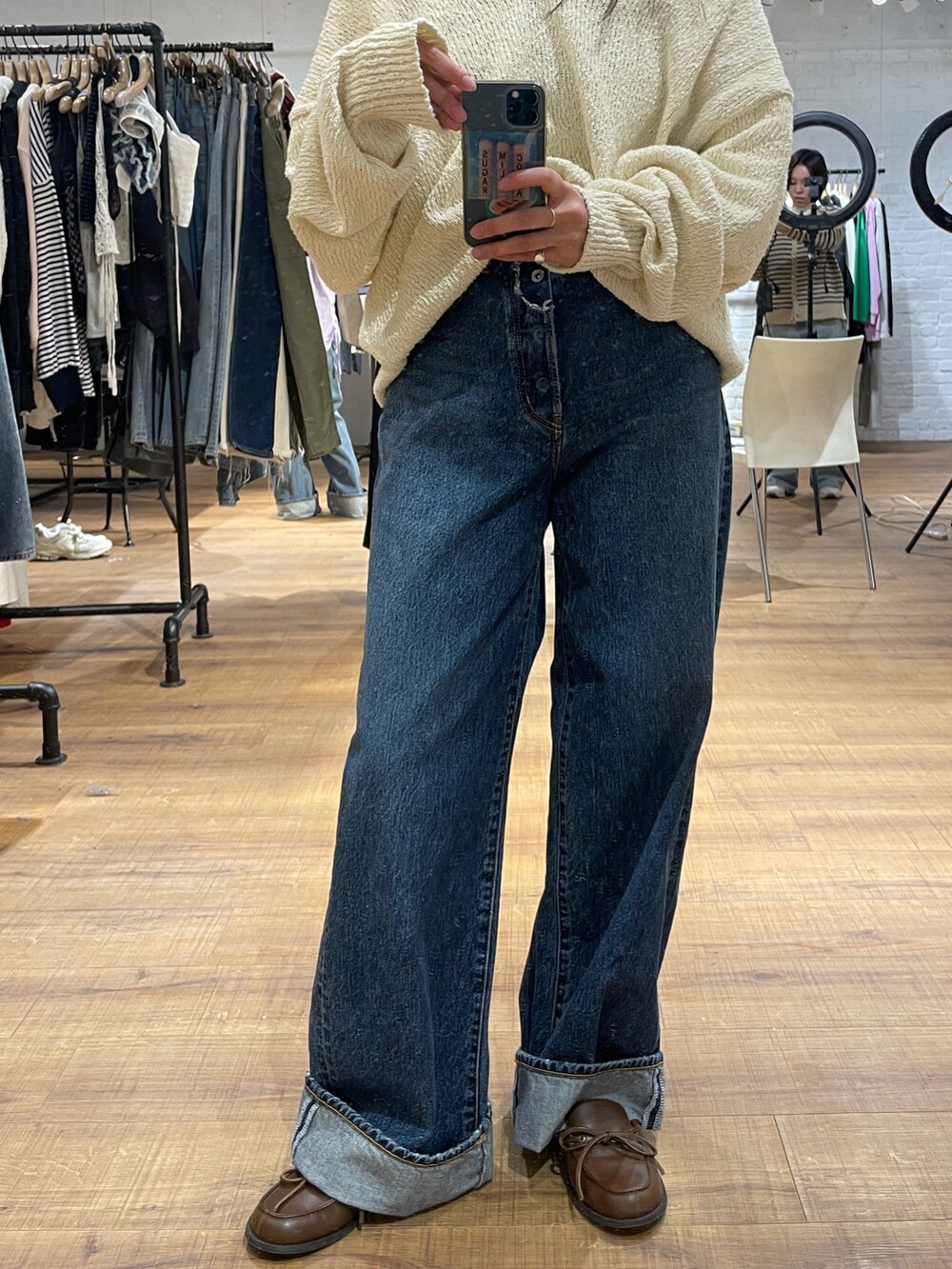 ブルー系のデニムパンツ、ホワイト系のニット/セーター、ブラウン系のローファーを着用したレディースの冬コーディネートの2枚目の写真
