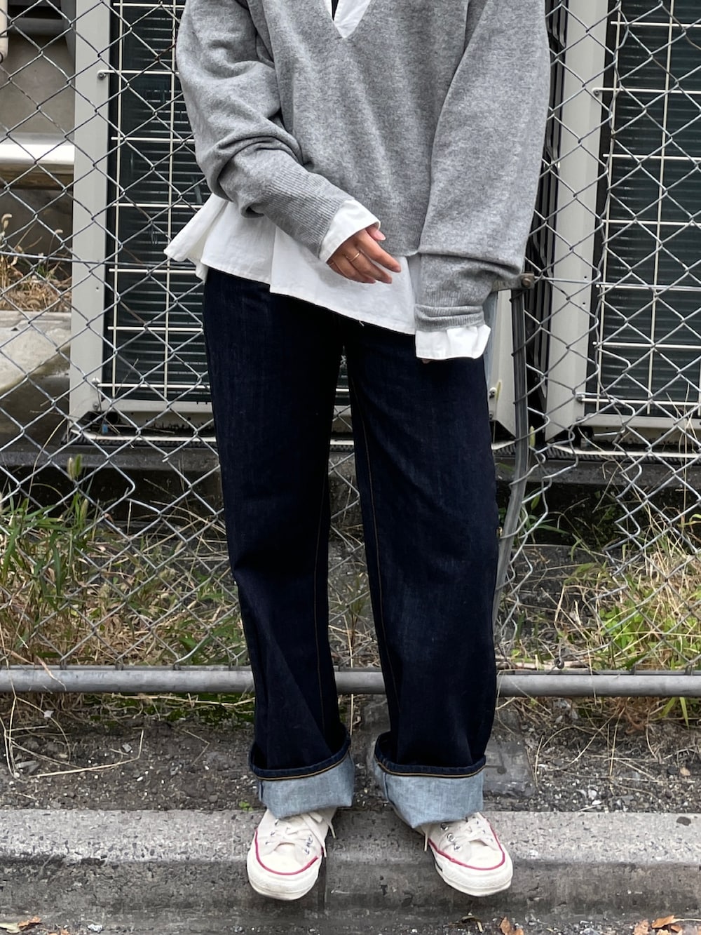 グレー系のニット/セーター、ブルー系のデニムパンツ、ホワイト系のシャツ/ブラウスを着用したレディースの秋コーディネートの7枚目の写真