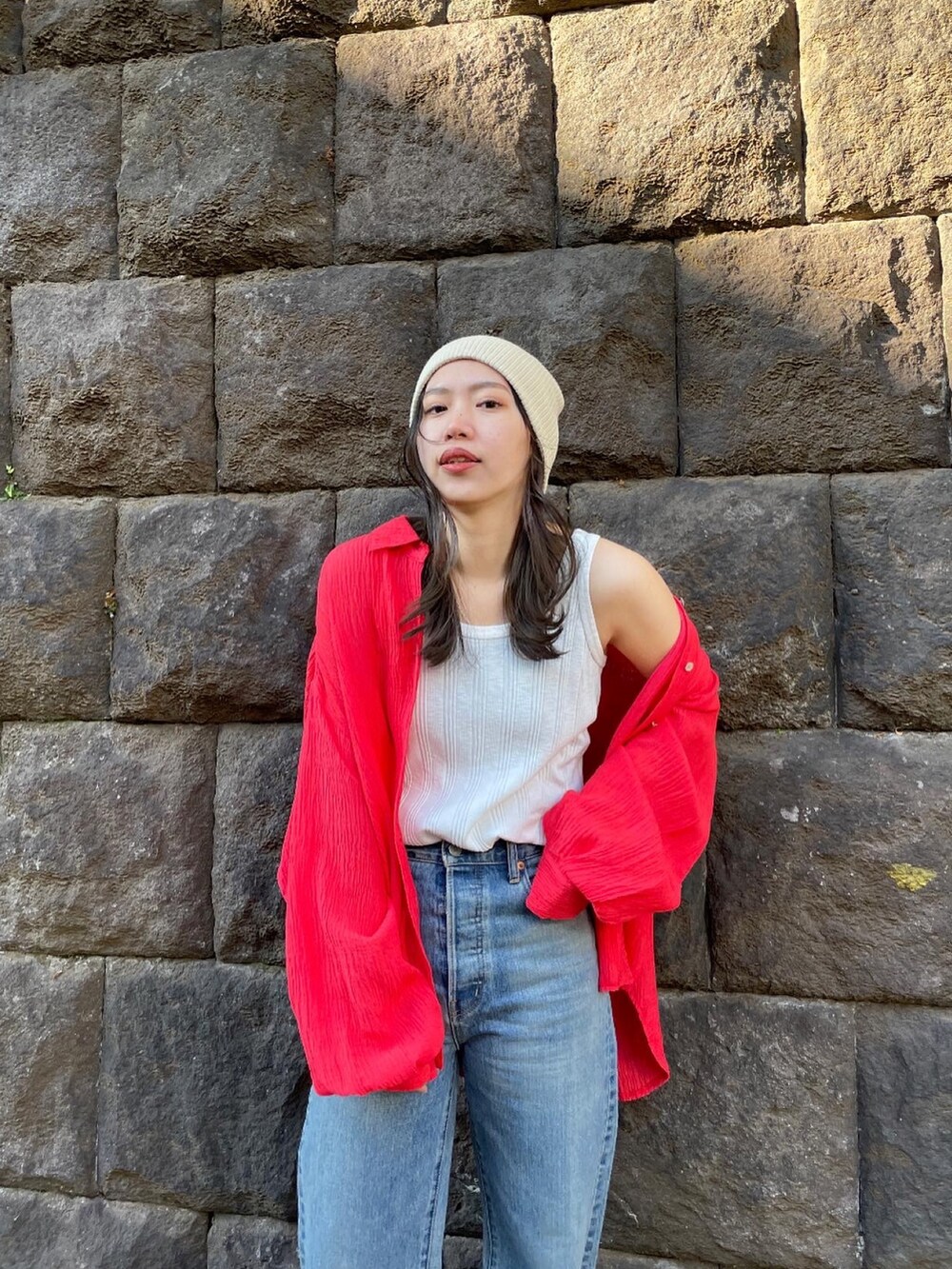 ブルー系のデニムパンツ、オレンジ系のシャツ/ブラウス、ホワイト系のタンクトップを着用したレディースの冬コーディネートの7枚目の写真