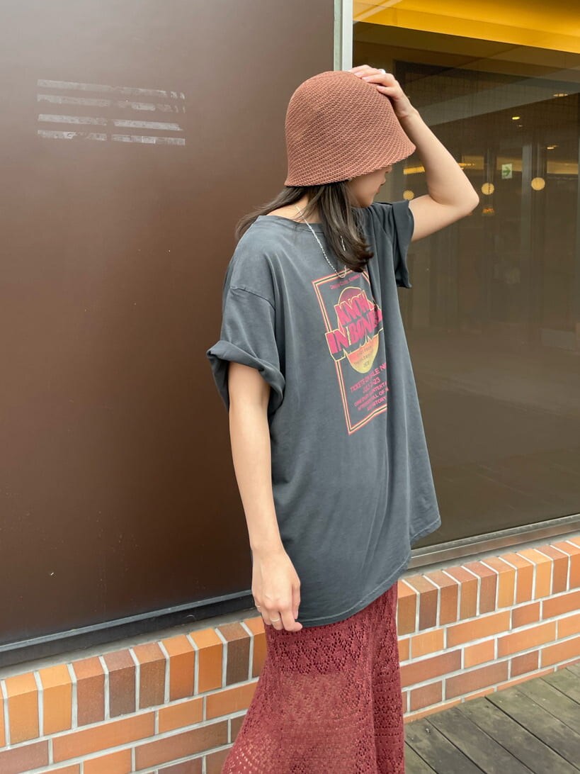 グレー系のTシャツ/カットソー、オレンジ系のスカート、ブラウン系のハットを着用したレディースの春コーディネートの7枚目の写真