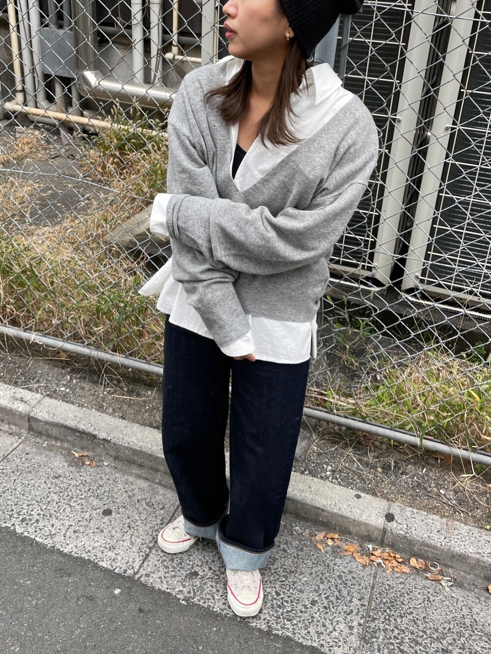 グレー系のニット/セーター、ブルー系のデニムパンツ、ホワイト系のシャツ/ブラウスを着用したレディースの秋コーディネートの4枚目の写真