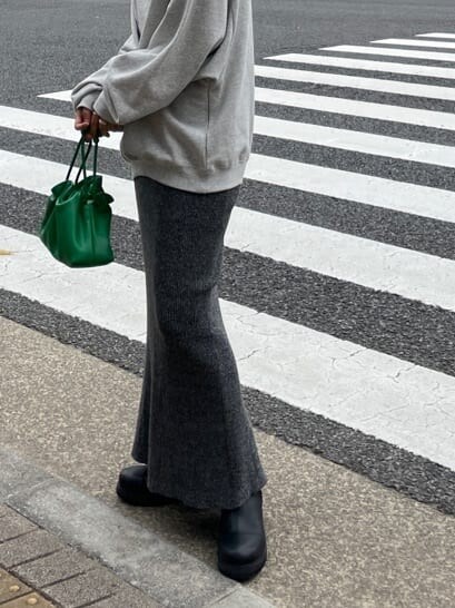 グリーン系のクラッチバッグ、グレー系のスウェット、グレー系のスカートを着用したレディースの秋コーディネートの5枚目の写真