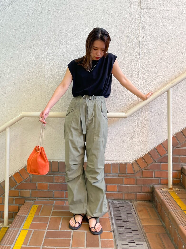 ブラック系のサンダル、オレンジ系のハンドバッグ、ベージュ系のその他パンツを着用したレディースの春コーディネートの2枚目の写真