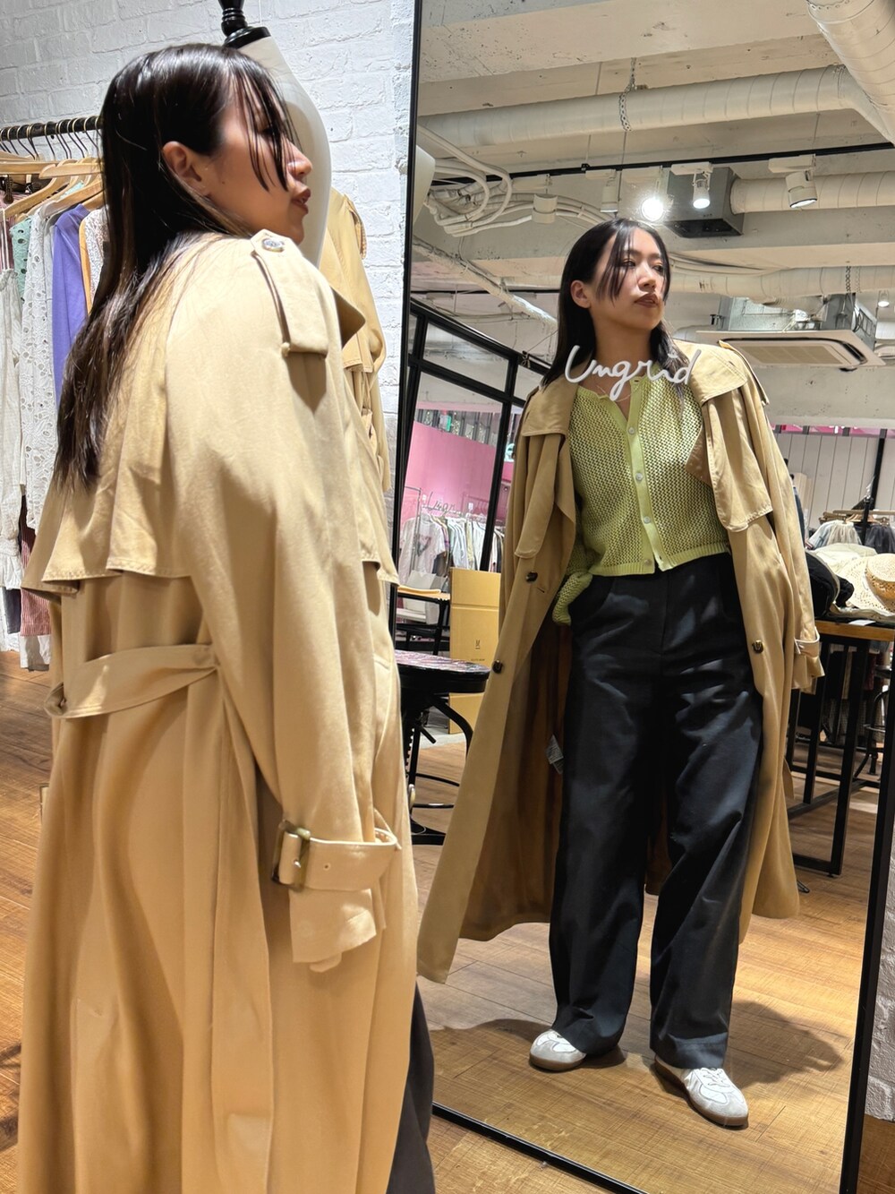 ベージュ系のトレンチコート、グリーン系のカーディガン/ボレロを着用したレディースの冬コーディネートの2枚目の写真